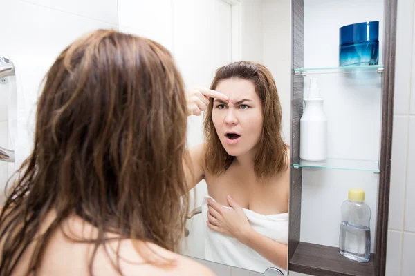 Problem hud koncept - förvånad kvinna som tittar på spegeln i badet — Stockfoto