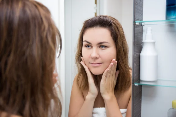 Concepto de cuidado de piel - mujer feliz mirando en el espejo —  Fotos de Stock