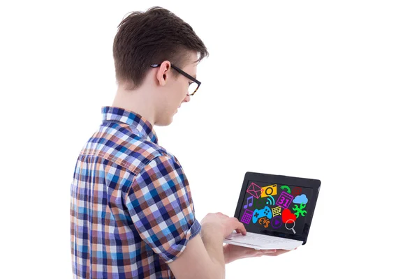 Back view of teenage boy using laptop with media icons and appli — Stock Photo, Image