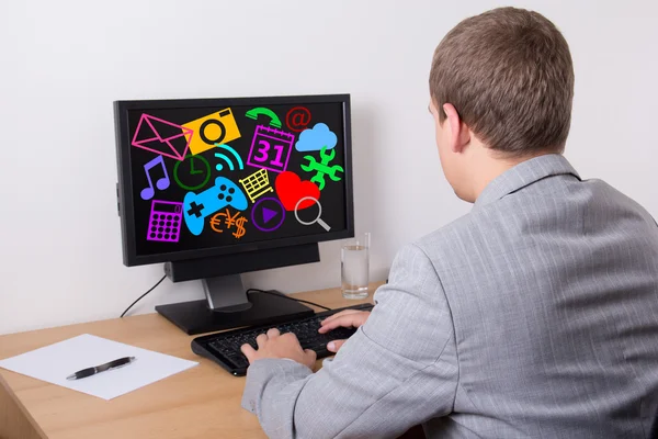 Geschäftsmann mit Personal Computer mit verschiedenen Anwendungen Stockbild