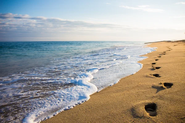 Close up of footprints in the sand at sunset — Stock Photo, Image