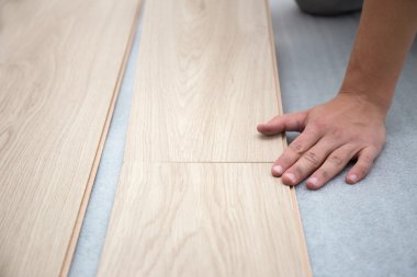 Marangoz, odaya kaplama döşeme kuruyor.