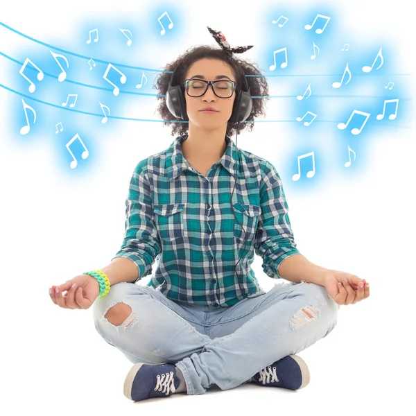 Happy african american teenage girl sitting in yoga pose and lis — Stock Photo, Image