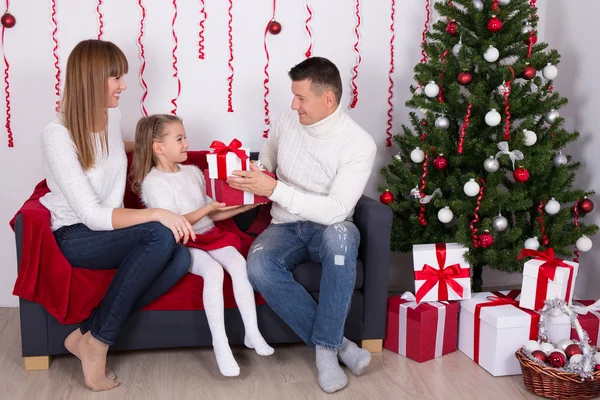 Familj utbyta gåvor framför julgran — Stockfoto