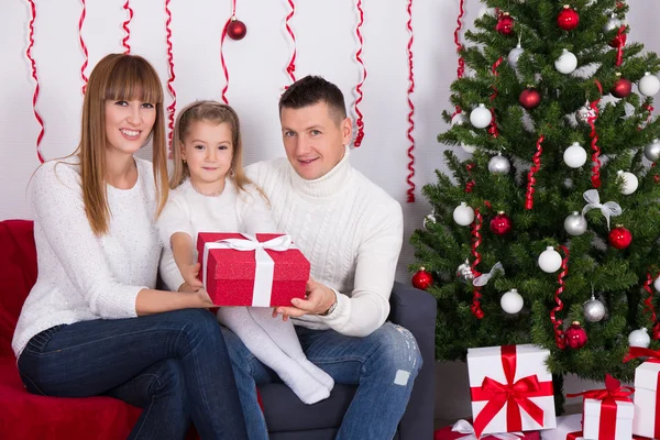 크리스마스 트리 앞에서 딸에 게 선물 주는 부모 — 스톡 사진