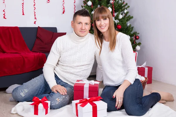 크리스마스 트리 앞에서 선물을 가진 사랑 스러운 커플 — 스톡 사진