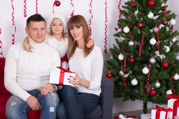 Famiglia allegra sveglia che si siede vicino all'albero di Natale a casa — Foto Stock