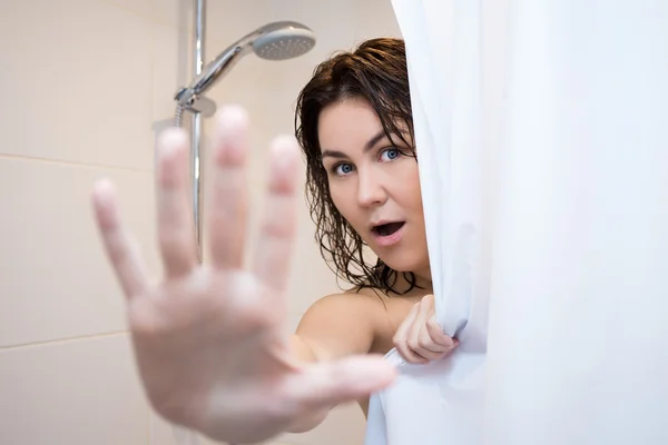 Young woman hiding behind shower curtain — Stock Photo, Image