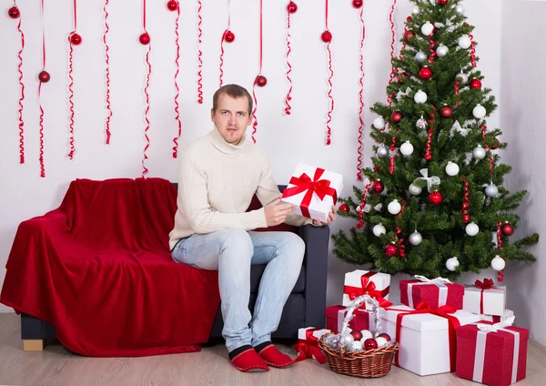 Mladý muž seděl v obýváku zdobené — Stock fotografie