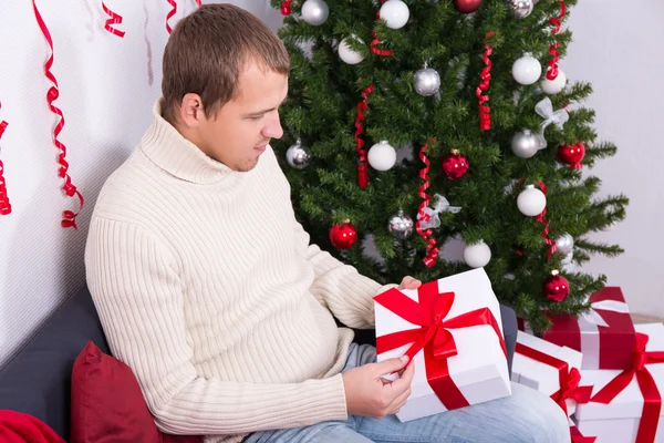 Ung man öppnar jul närvarande ask — Stockfoto