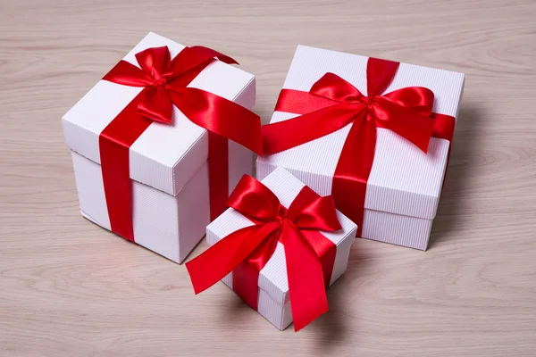 Cajas de regalo con cinta roja sobre fondo de madera —  Fotos de Stock