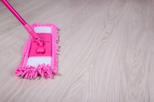 Cleaning concept -close up of mop on wooden floor — Stock Photo, Image