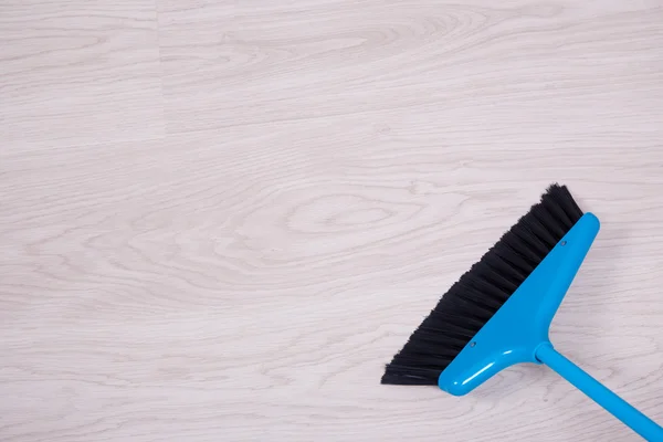 Concetto di pulizia - primi piani di blu scopa spazzare pavimento — Foto Stock