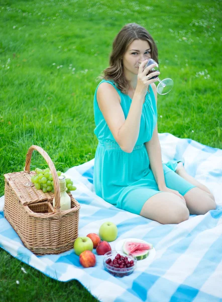 Krásná žena, pití červeného vína v letním parku — Stock fotografie