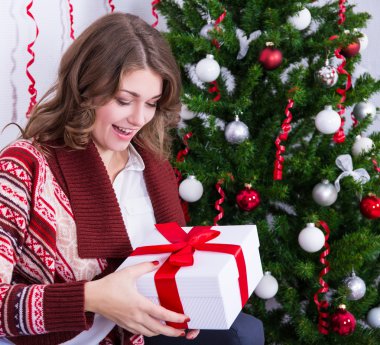 genç kızla mutlu Noel ağacı yakınındaki hediye kutusu