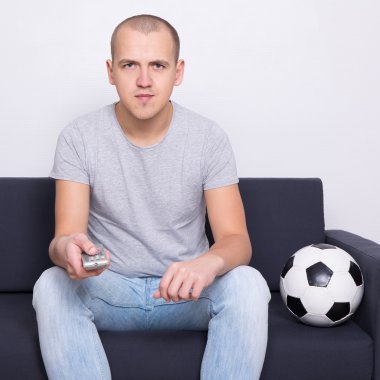 genç adam evde TV'de futbol izlerken