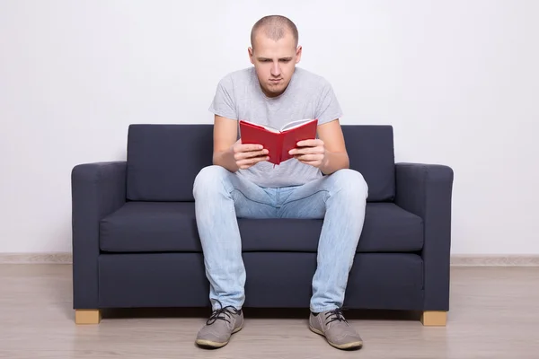 handsome man sitting on sofa and reading book