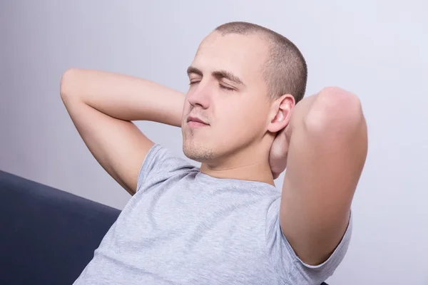 Young man lying on sofa at home — Stock Photo, Image