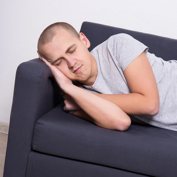 Hezký muž spí na gauči doma — Stock fotografie