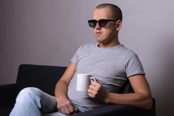 Hombre guapo en gafas 3d sentado en sofá y viendo la película — Foto de Stock