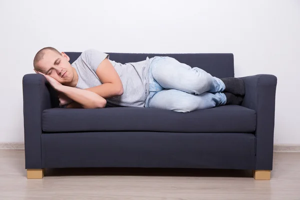 Мужчина спит дома на диване — стоковое фото
