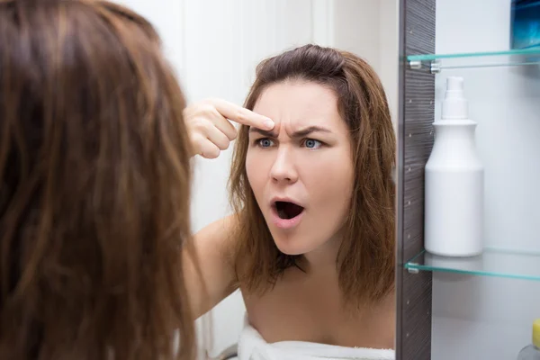 Πρόβλημα δέρμα έννοια - γυναίκα κοιτάζοντας καθρέφτη στο μπάνιο — Φωτογραφία Αρχείου