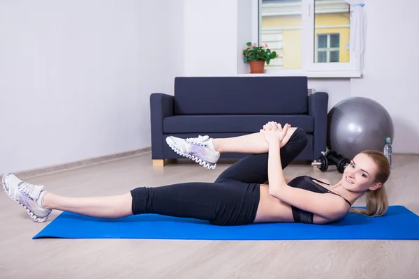 Sportieve levensstijl - jonge mooie slanke vrouw doen oefeningen op — Stockfoto