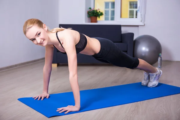 Gelukkige vrouw doen push-up oefening thuis — Stockfoto