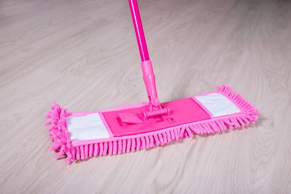 Close up van houten vloer met roze mop — Stockfoto