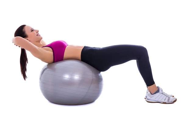 Štíhlá žena v sportovní oděv dělá cvičení na fitness míč isolat Stock Snímky