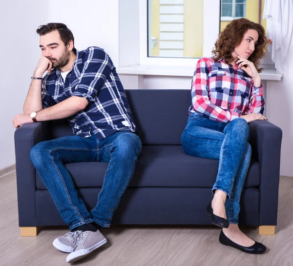 Portrait of displeased couple sitting back to back in living roo — Stok Foto