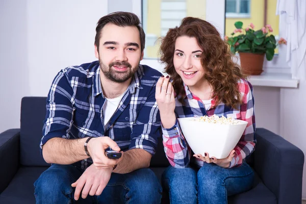 Happy young couple watching tv or movie at home — Stok Foto