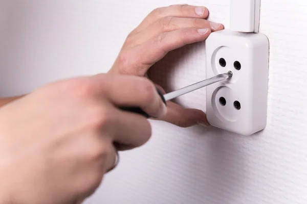 Male hands with screwdriver installing electrical socket on wall — Stock Photo, Image