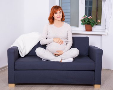 oturma odasında genç hamile kadın