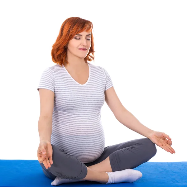 Junge ziemlich schwanger Frau tun Yoga isoliert auf weiss — Stockfoto