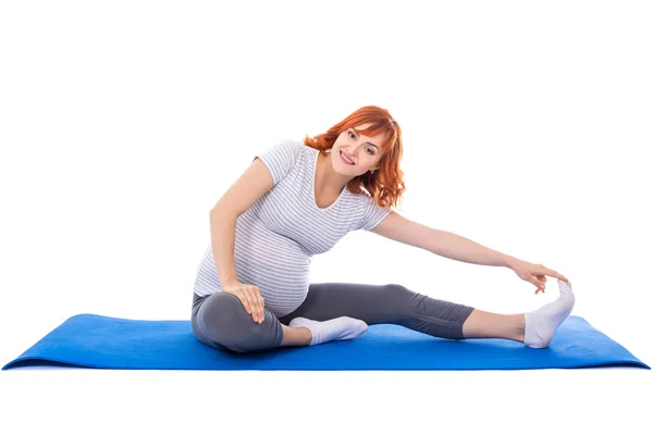 Junge schwangere Frau tun, Dehnung Übungen zum Yoga Mat isol — Stockfoto