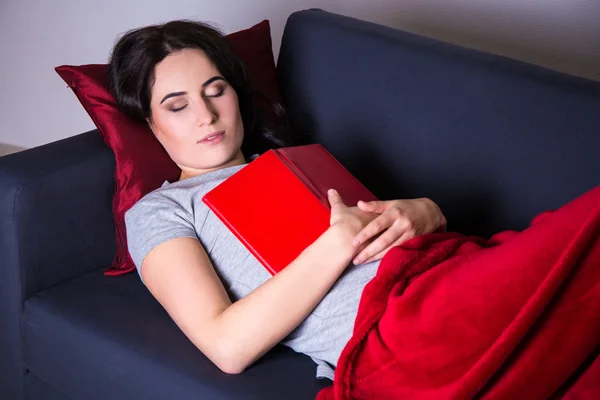 Nahaufnahme der Frau schläft mit Buch auf dem Sofa zu Hause — Stockfoto