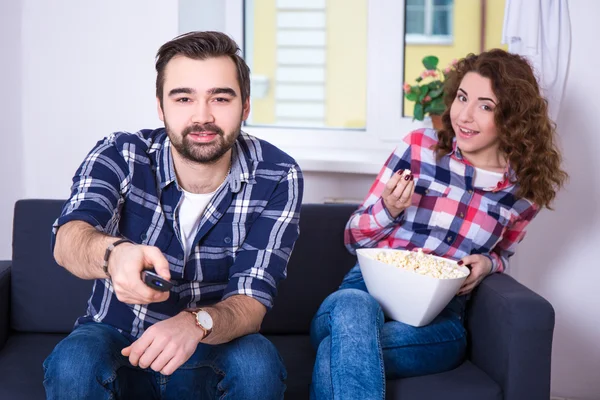 Pareja joven con palomitas de maíz viendo televisión o una película — Foto de Stock