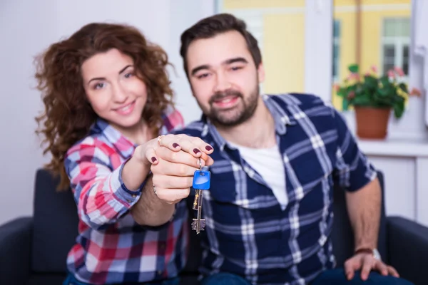 Fastigheter koncept - glada leende unga par visar nycklar — Stockfoto
