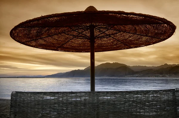 Sombrilla de silueta en la playa y puesta de sol —  Fotos de Stock