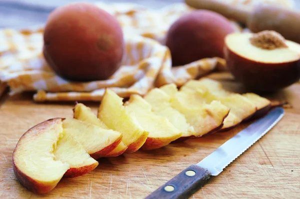 Slices peaches and knife — Stock Photo, Image