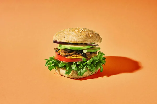 Veganer Burger Mit Gebratenen Pilzen Und Anderem Gemüse Auf Leuchtend lizenzfreie Stockbilder