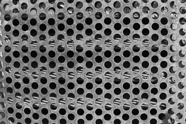 Vieille grille métallique avec trous ronds dans une texture de bâtiment abandonnée. — Photo