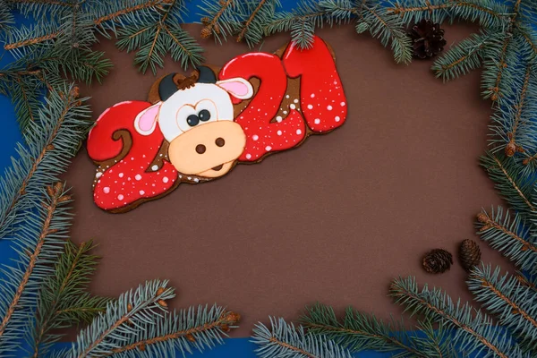 Gingerbread Cow or bull. New years Top view. Year of the bull. Branches of spruce on a brown background. Copy space.