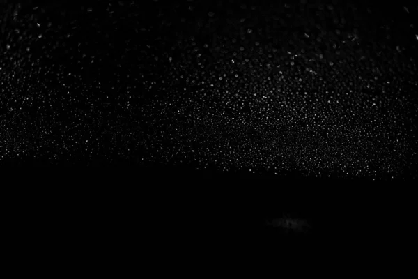 Regentropfen auf schwarzem Glashintergrund in Nahaufnahme. Wassertropfen schwarze Textur. — Stockfoto