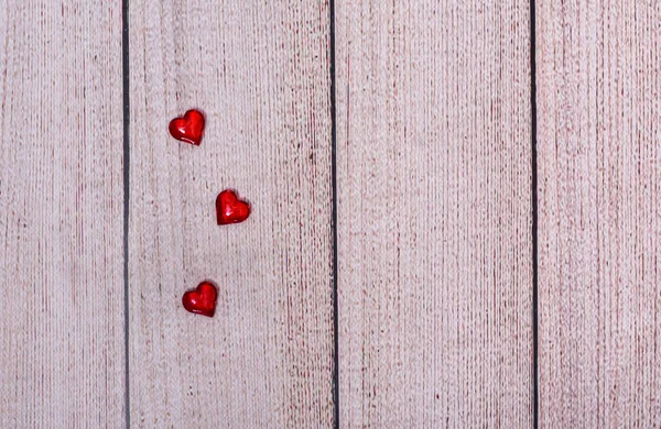 Corazones rojos sobre un fondo de madera. espacio para copiar. — Foto de Stock