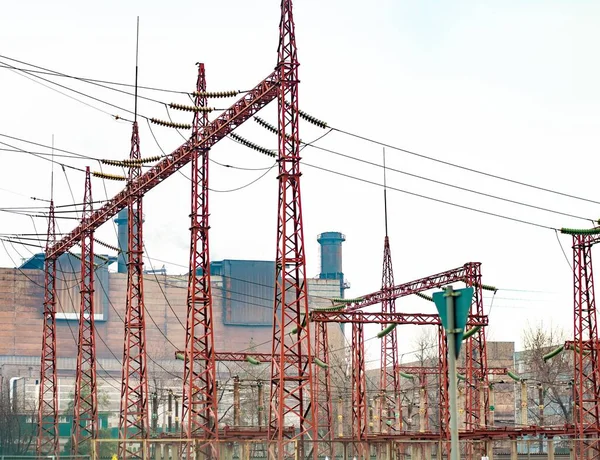 Bir sanayi fabrikasının arka planında yüksek voltajlı elektrik hatları var..