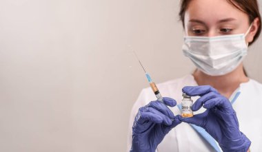 COVID-19 koronavirüs aşısı. Hemşire hastayı aşılamaya hazırlanıyor.. 