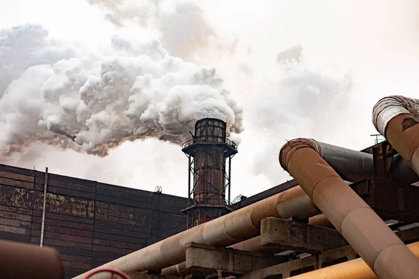 Large industrial metallurgical plant on a cloudy day. Heavy smoke from smokestacks emit into the air — Stock Photo, Image