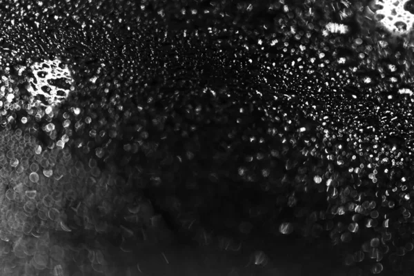 Water drops in the black bokeh background while outside is lights are shining. — Stock Photo, Image